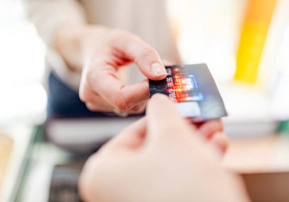 istockphoto-970053100-612x612 Close-up of handing credit card to cashier. Note to inspector: Design elements is design by us, name and credit number is generic